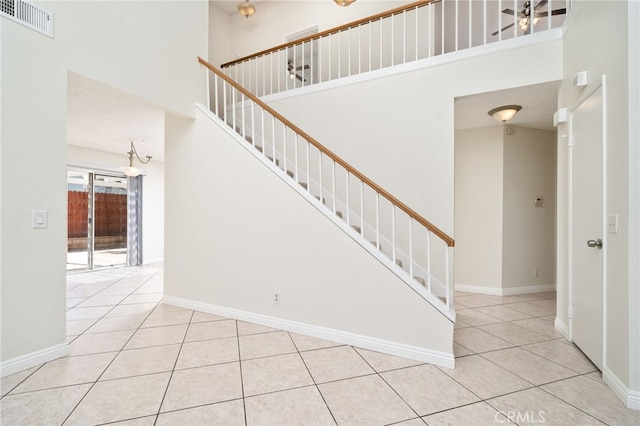 11500 Winery Dr, Fontana, CA 92337 - stairs featuring a towering ceiling, tile patterned flooring, and a chandelier
