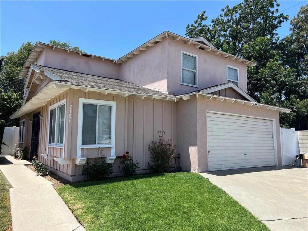 21801 Foley Ave, Carson, CA 90745 - view of front of property featuring board and batten siding, driveway, a garage, and stucco siding