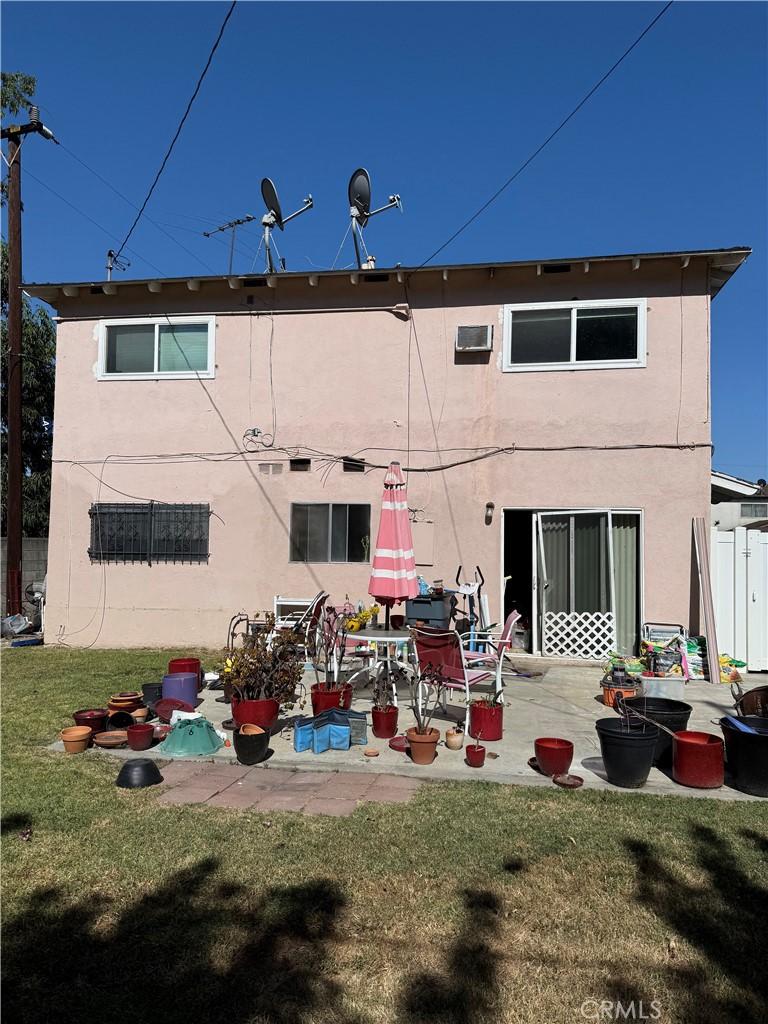21801 Foley Ave, Carson, CA 90745 - back of house featuring stucco siding, a lawn, and a patio area