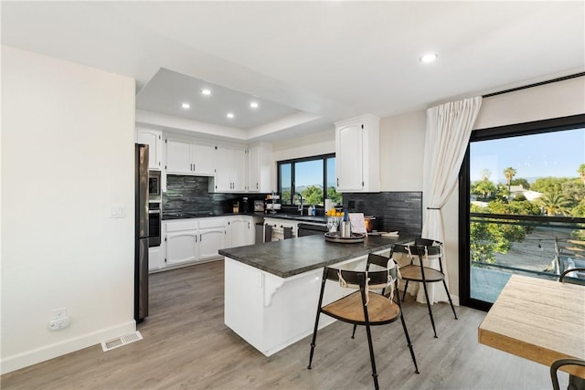 33851 Madera De Playa, Temecula, CA 92592 - kitchen with a peninsula, tasteful backsplash, white cabinetry, dark countertops, and recessed lighting