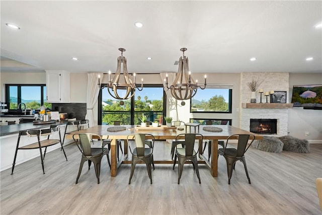 33851 Madera De Playa, Temecula, CA 92592 - dining area featuring a chandelier, light wood-type flooring, a stone fireplace, and recessed lighting