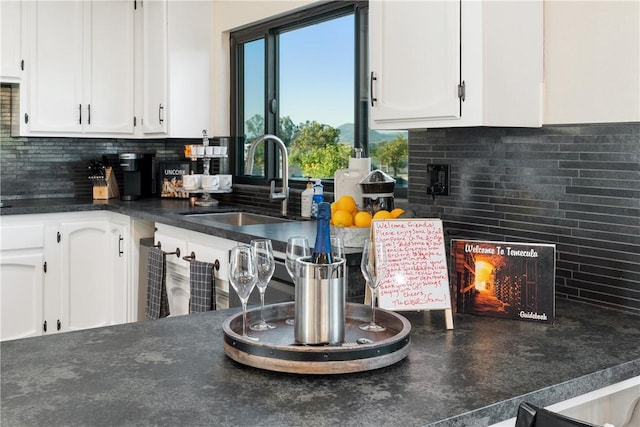 33851 Madera De Playa, Temecula, CA 92592 - kitchen with white cabinets, dark countertops, and backsplash