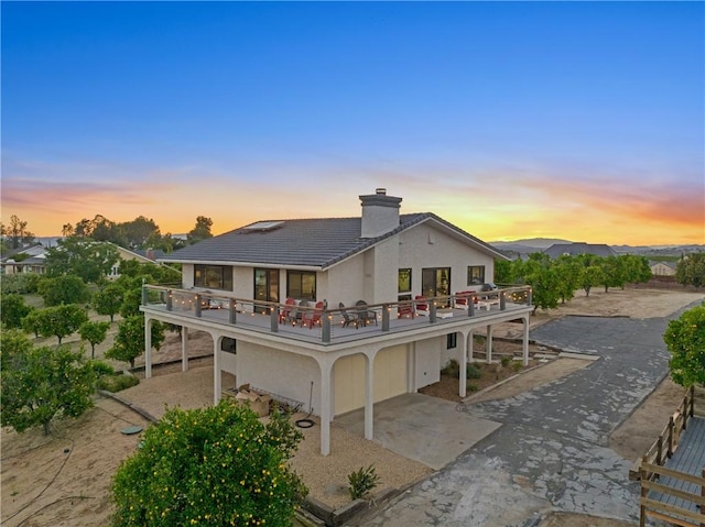 33851 Madera De Playa, Temecula, CA 92592 - back of house featuring a balcony, a chimney, stucco siding, concrete driveway, and a carport