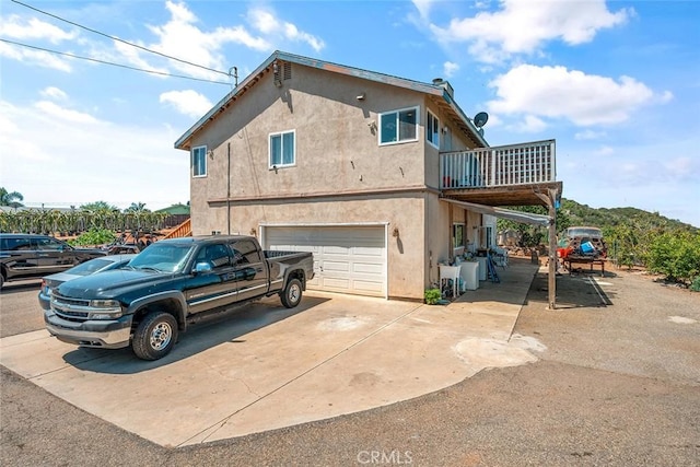 1996 Rainbow Glen Rd, Fallbrook, CA 92028 - rear view of property featuring driveway, an attached garage, stucco siding, and a balcony