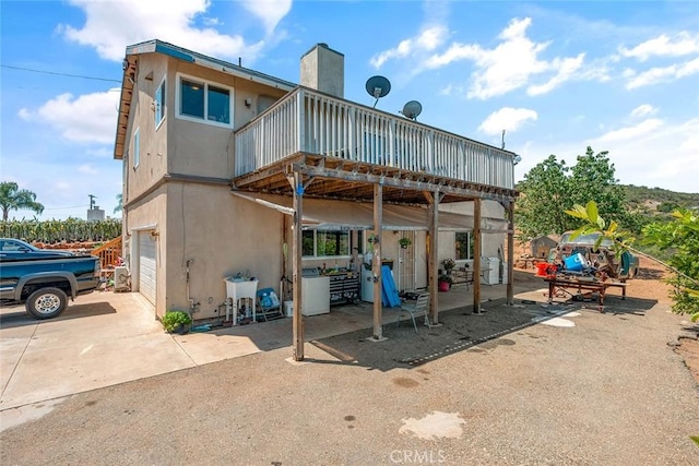 1996 Rainbow Glen Rd, Fallbrook, CA 92028 - back of property featuring an attached garage, a chimney, stucco siding, a deck, and concrete driveway