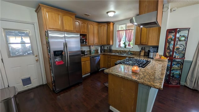 522 S 5th St, Montebello, CA 90640 - kitchen with appliances with stainless steel finishes, exhaust hood, a peninsula, dark wood-style floors, and dark stone counters