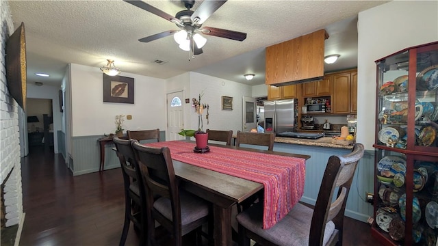 522 S 5th St, Montebello, CA 90640 - dining room featuring a ceiling fan, dark wood-style flooring, a textured ceiling, wainscoting, and a brick fireplace