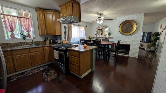 522 S 5th St, Montebello, CA 90640 - kitchen featuring stainless steel gas range oven, a peninsula, ceiling fan, under cabinet range hood, and brown cabinetry