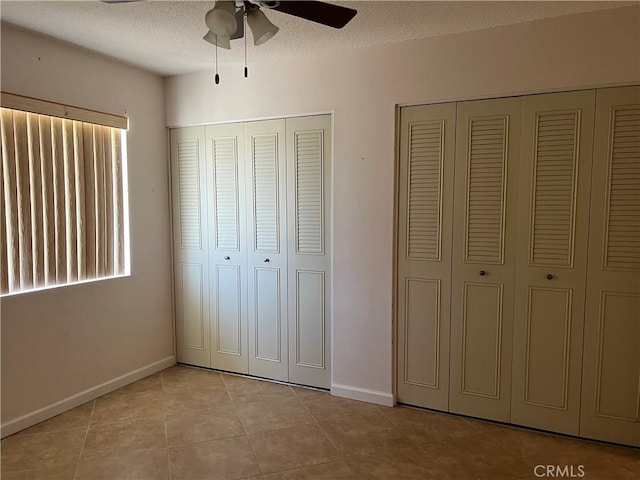 1441 Edgewood Ln, Hemet, CA 92543 - unfurnished bedroom with tile patterned floors, a textured ceiling, two closets, and ceiling fan