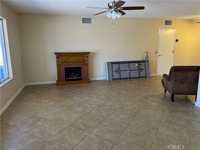1441 Edgewood Ln, Hemet, CA 92543 - living area featuring ceiling fan, tile patterned floors, a textured ceiling, and a fireplace