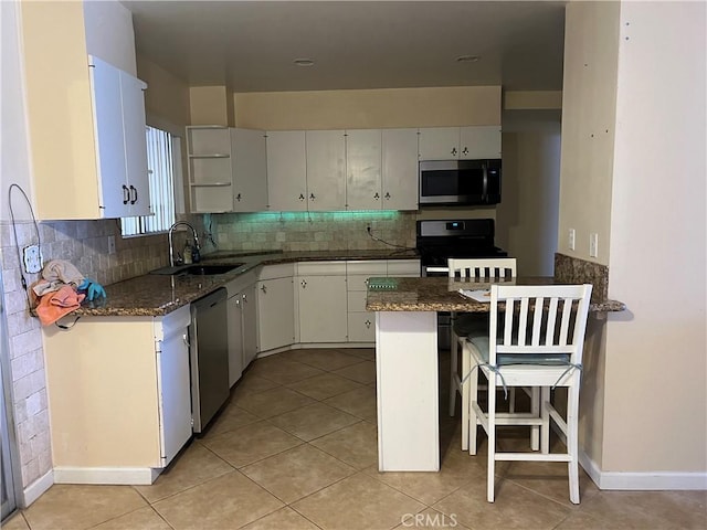 1441 Edgewood Ln, Hemet, CA 92543 - kitchen featuring appliances with stainless steel finishes, decorative backsplash, light tile patterned floors, a kitchen bar, and a peninsula