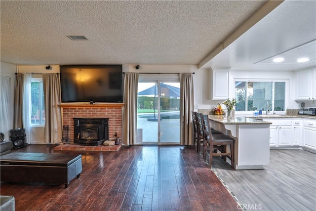 6073 Cameo St, Rancho Cucamonga, CA 91701 - kitchen with white cabinetry, a textured ceiling, open floor plan, hardwood / wood-style floors, and a peninsula