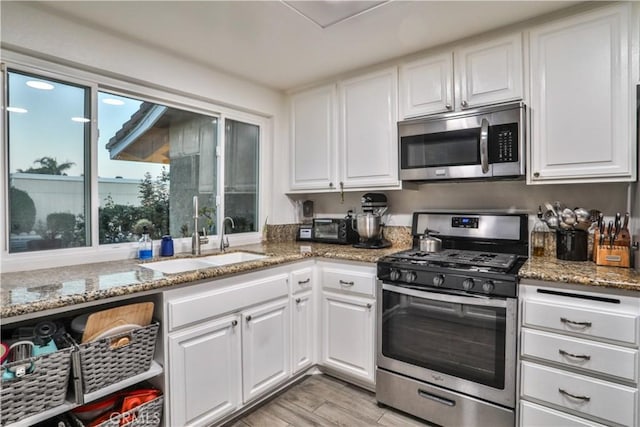 6073 Cameo St, Rancho Cucamonga, CA 91701 - kitchen featuring stainless steel appliances, white cabinetry, light wood-style flooring, and light stone counters