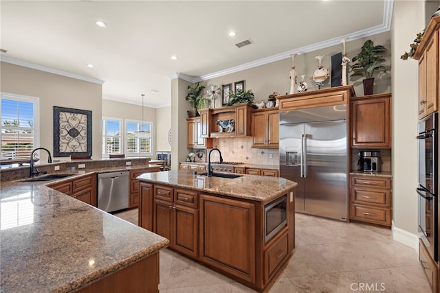 38150 Via Huerta, Murrieta, CA 92562 - kitchen with built in appliances, a kitchen island with sink, tasteful backsplash, brown cabinetry, and dark stone counters