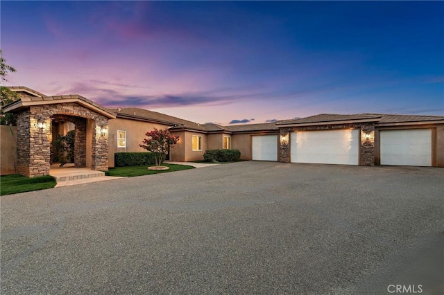 38150 Via Huerta, Murrieta, CA 92562 - view of front of home with stone siding, a garage, driveway, and stucco siding