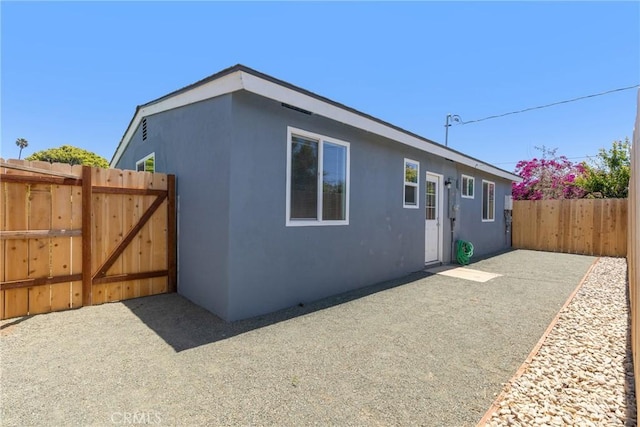 715 N 3rd St, Lompoc, CA 93436 - view of side of home with stucco siding, a patio, and a gate