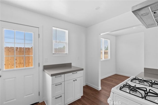 715 N 3rd St, Lompoc, CA 93436 - kitchen with dark wood-type flooring, exhaust hood, white cabinetry, and white range with gas stovetop