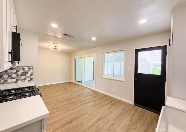 6692 Elm Ave, San Bernardino, CA 92404 - kitchen featuring light wood-style flooring, white cabinets, light countertops, and recessed lighting