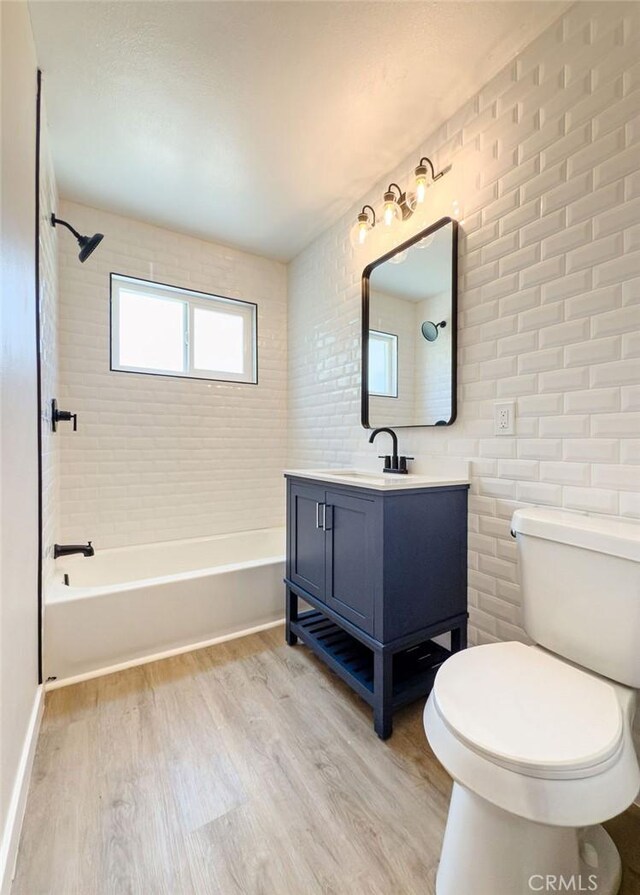 6692 Elm Ave, San Bernardino, CA 92404 - bathroom featuring wood finished floors, vanity, and bathtub / shower combination
