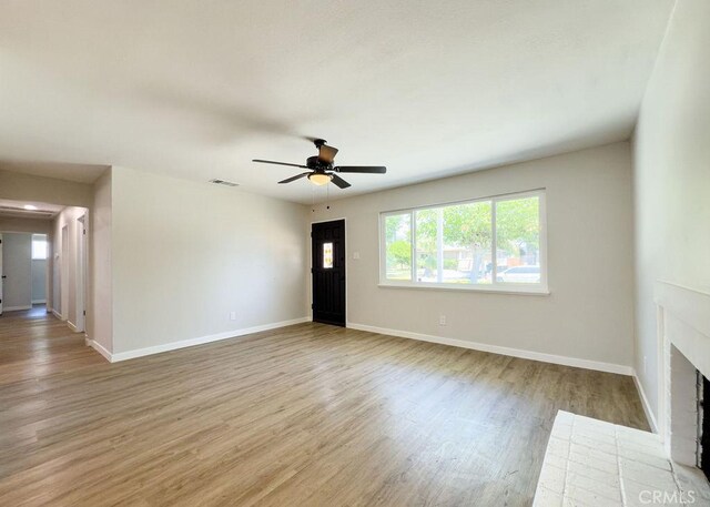 6692 Elm Ave, San Bernardino, CA 92404 - unfurnished living room with a ceiling fan, wood finished floors, and a fireplace with flush hearth