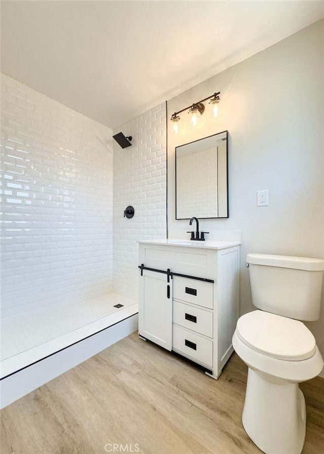 6692 Elm Ave, San Bernardino, CA 92404 - bathroom featuring tiled shower, wood finished floors, and vanity
