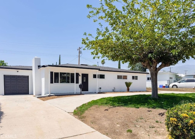 6692 Elm Ave, San Bernardino, CA 92404 - ranch-style home featuring driveway, an attached garage, stucco siding, and a chimney