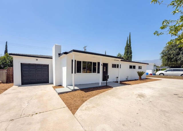 6692 Elm Ave, San Bernardino, CA 92404 - single story home featuring stucco siding, a garage, concrete driveway, and a chimney