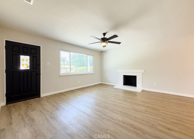 6692 Elm Ave, San Bernardino, CA 92404 - foyer entrance featuring light wood-style floors, ceiling fan, and a brick fireplace