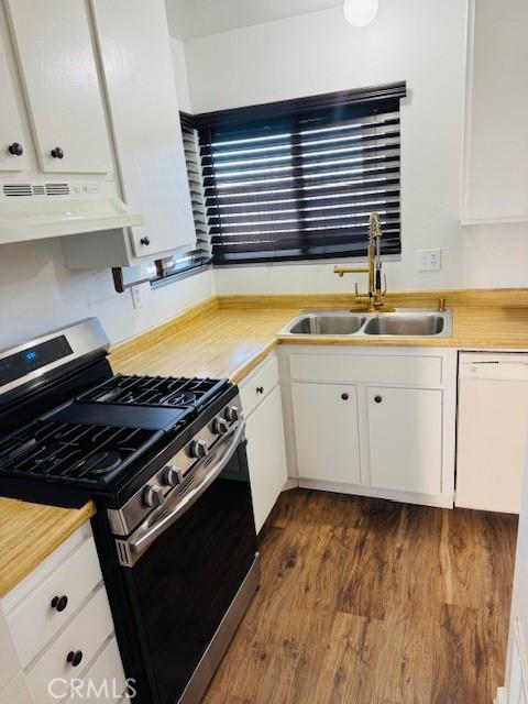 98 Lori Way, Banning, CA 92220 - kitchen featuring stainless steel gas range, under cabinet range hood, white dishwasher, white cabinets, and dark wood-style floors