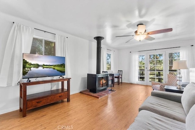 23717 Scenic Dr, Crestline, CA 92325 - living area featuring plenty of natural light, a wood stove, wood finished floors, and ceiling fan