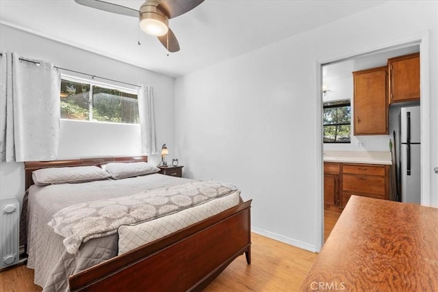 23717 Scenic Dr, Crestline, CA 92325 - bedroom featuring light wood-style floors, freestanding refrigerator, and multiple windows