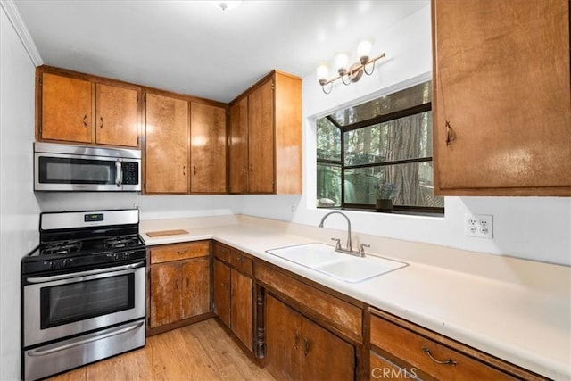 23717 Scenic Dr, Crestline, CA 92325 - kitchen featuring appliances with stainless steel finishes, brown cabinetry, light wood-type flooring, and light countertops
