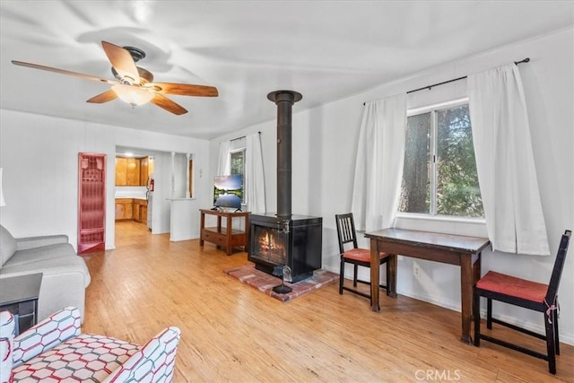 23717 Scenic Dr, Crestline, CA 92325 - living area with a wood stove, light wood-type flooring, and a ceiling fan