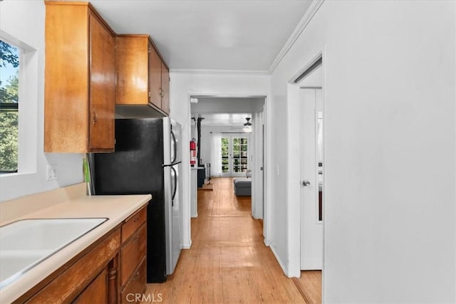 23717 Scenic Dr, Crestline, CA 92325 - kitchen with freestanding refrigerator, brown cabinets, light wood finished floors, light countertops, and crown molding