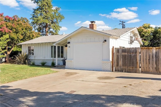 18 El Cerrito Dr, Chico, CA 95973 - view of front of home with brick siding, a garage, board and batten siding, and a chimney