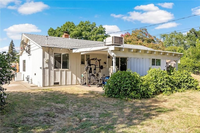 18 El Cerrito Dr, Chico, CA 95973 - back of property featuring a chimney, board and batten siding, a patio area, and a yard
