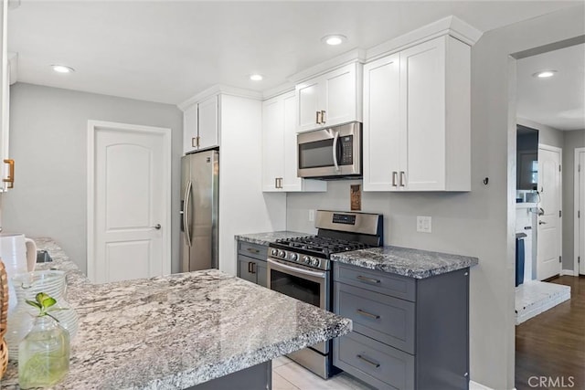 18 El Cerrito Dr, Chico, CA 95973 - kitchen with appliances with stainless steel finishes, recessed lighting, white cabinets, light stone countertops, and light wood-style floors