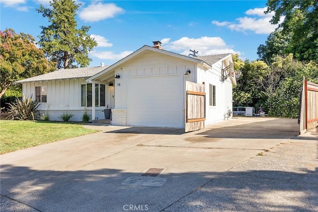 18 El Cerrito Dr, Chico, CA 95973 - view of front facade with driveway, board and batten siding, roof with shingles, a garage, and a front lawn