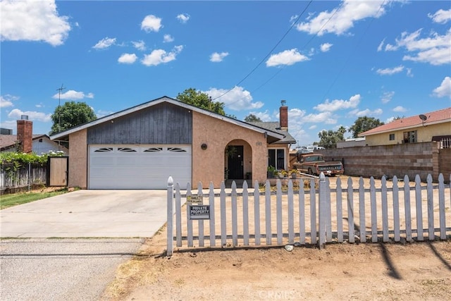 5983 Jones Ave, Riverside, CA 92505 - view of front of house with a fenced front yard, a garage, driveway, and stucco siding