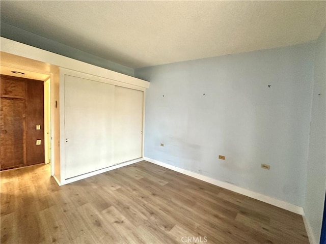 13620 Alderwood Ln Unit 76D, Seal Beach, CA 90740 - unfurnished bedroom featuring light wood-type flooring, a closet, and a textured ceiling
