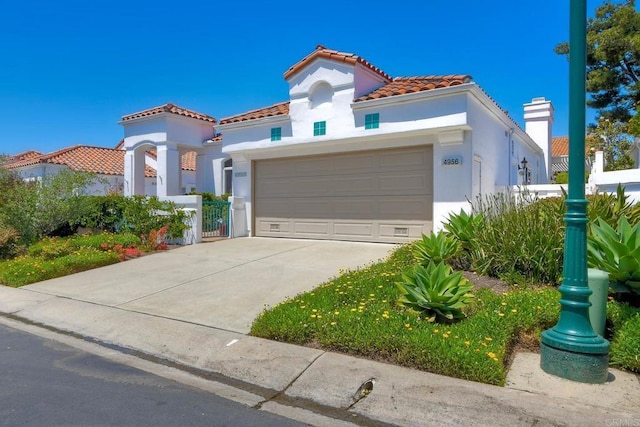 4956 Lamia Way, Oceanside, CA 92056 - mediterranean / spanish-style house featuring stucco siding, concrete driveway, a tiled roof, and an attached garage
