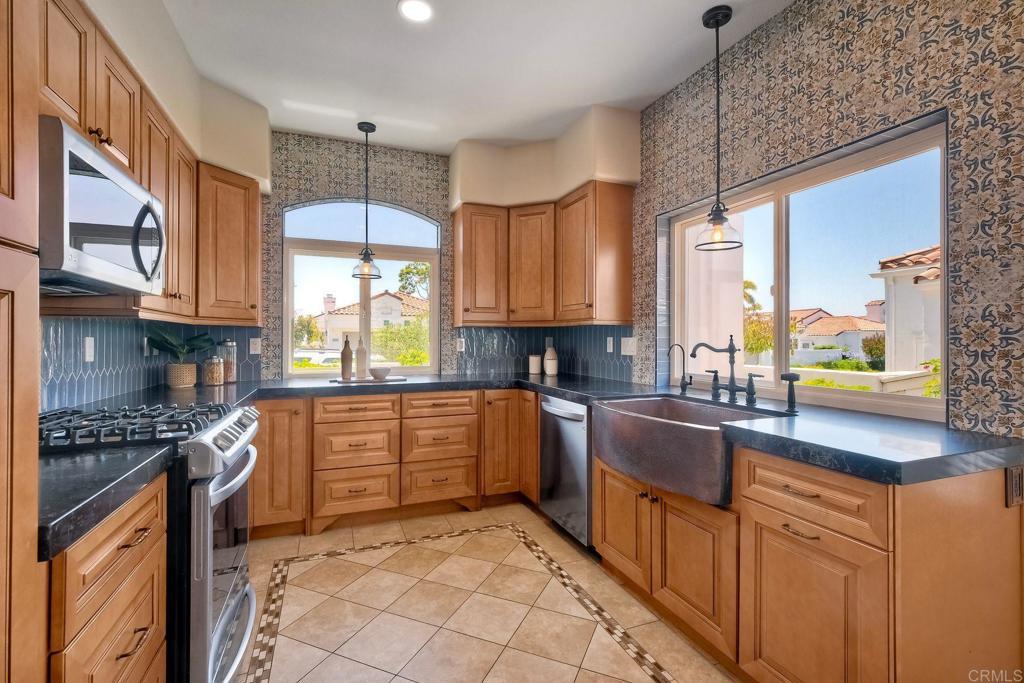 4956 Lamia Way, Oceanside, CA 92056 - kitchen featuring appliances with stainless steel finishes, healthy amount of natural light, dark countertops, wallpapered walls, and recessed lighting