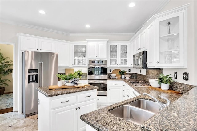 18 Argento, Mission Viejo, CA 92692 - kitchen featuring stainless steel appliances, dark stone countertops, white cabinetry, a kitchen island, and ornamental molding
