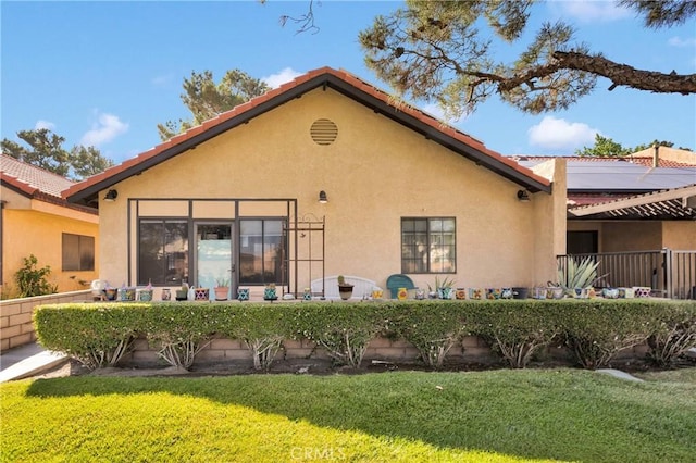 11714 Oak St, Apple Valley, CA 92308 - back of property featuring solar panels, stucco siding, and a lawn