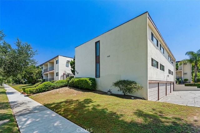 820 N Raymond Ave, Pasadena, CA 91103 - view of property exterior featuring a garage, driveway, stucco siding, and a lawn