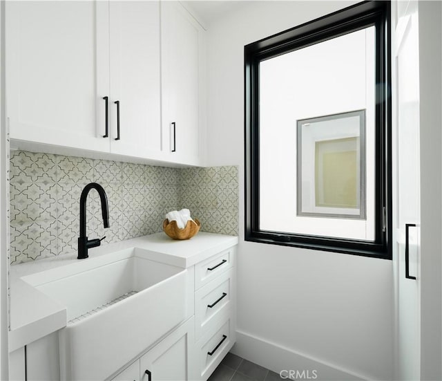 1313 Ocean Ave, Seal Beach, CA 90740 - kitchen with white cabinetry, tasteful backsplash, light countertops, and dark tile patterned flooring