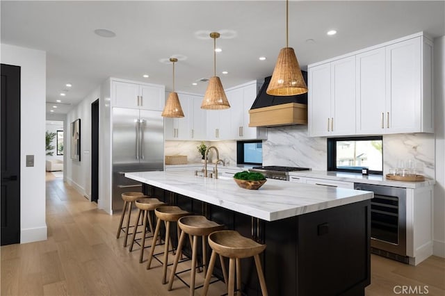 1315 Ocean Ave, Seal Beach, CA 90740 - kitchen with wine cooler, custom range hood, stainless steel built in refrigerator, light wood finished floors, and tasteful backsplash