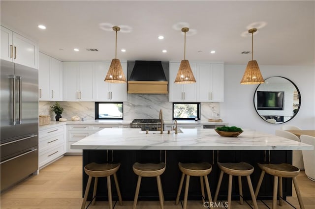 1315 Ocean Ave, Seal Beach, CA 90740 - kitchen featuring high quality fridge, an island with sink, light stone countertops, backsplash, and recessed lighting