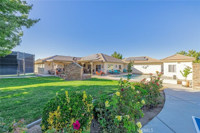 2534 Desert Rose Dr, Lancaster, CA 93536 - rear view of house with solar panels, a patio, and stucco siding
