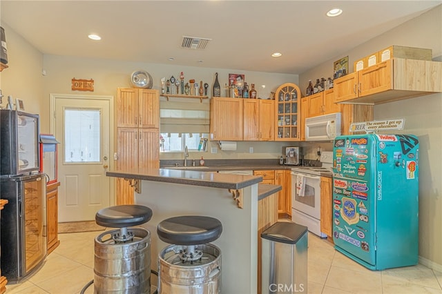 2534 Desert Rose Dr, Lancaster, CA 93536 - kitchen featuring white appliances, a kitchen bar, light tile patterned flooring, glass insert cabinets, and recessed lighting